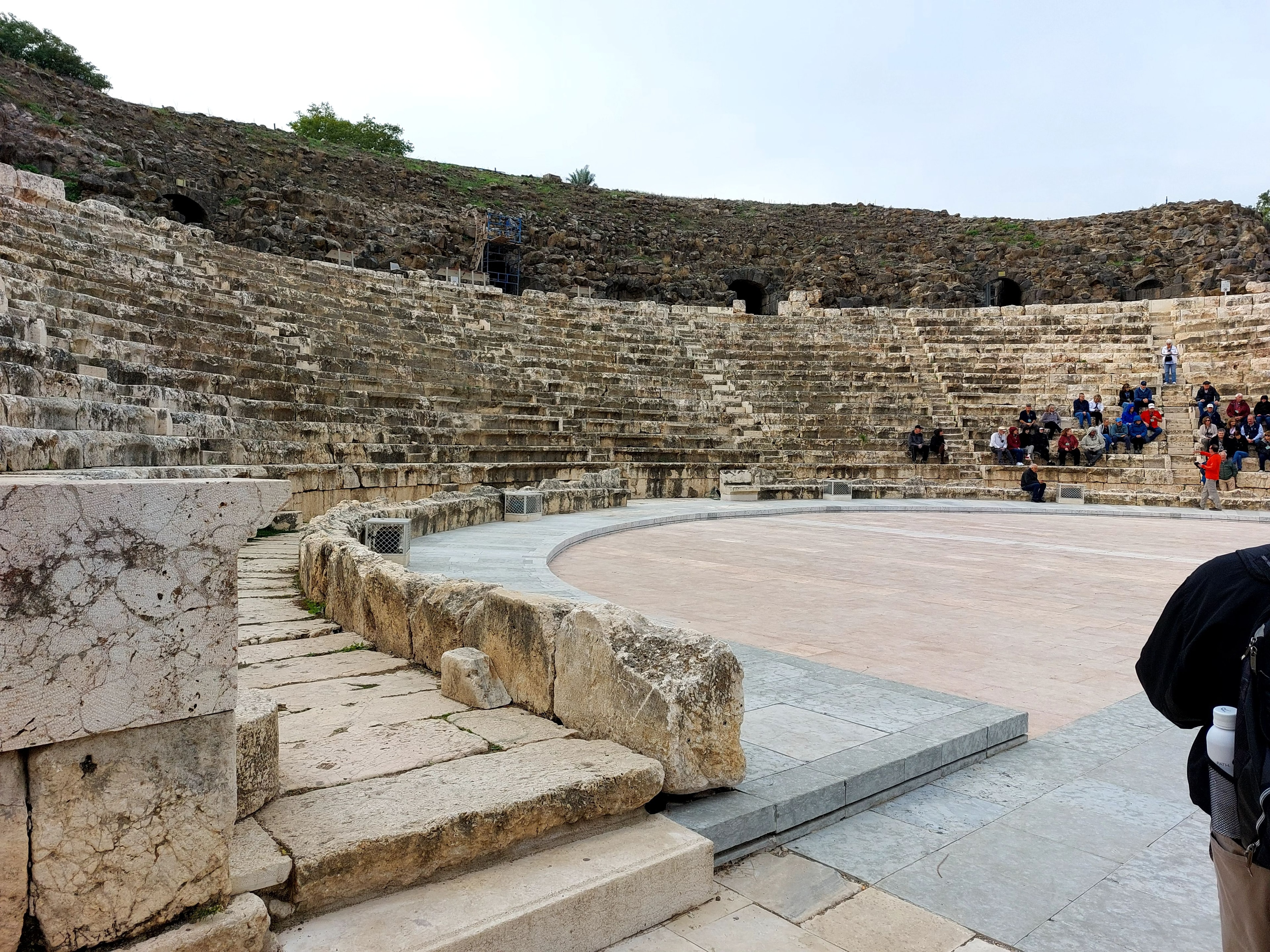 Interior of the Roman theater at Beth-Shan showing the semicircular stone seating tiers and the restored stage floor