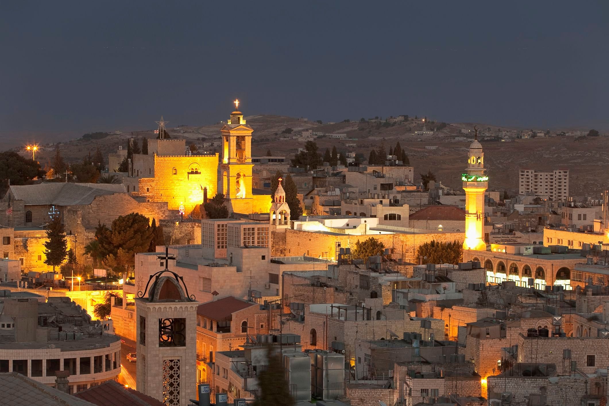Bethlehem at night — illuminated churches and minarets over the ancient city skyline