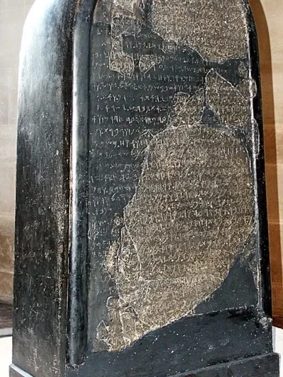 The Mesha Stele, a black basalt stone inscribed with ancient Moabite text, discovered in Dibon, Jordan in 1868, now housed in the Louvre