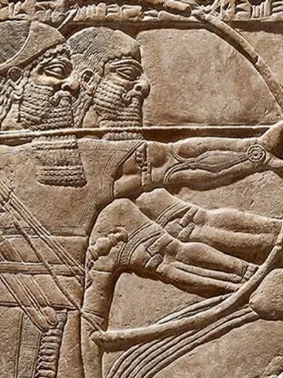 Ancient Assyrian stone relief carving showing a bearded warrior drawing a bow — a detail from a Neo-Assyrian palace relief depicting a soldier in battle